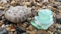 Der Glass Beach (deutsch: Glas Strand) besteht nämlich bei näherer Betrachtung nicht aus Kieselsteinen, sondern aus abgeschliffenem Glas, das mal weiß, rot oder grün am Boden schimmert.