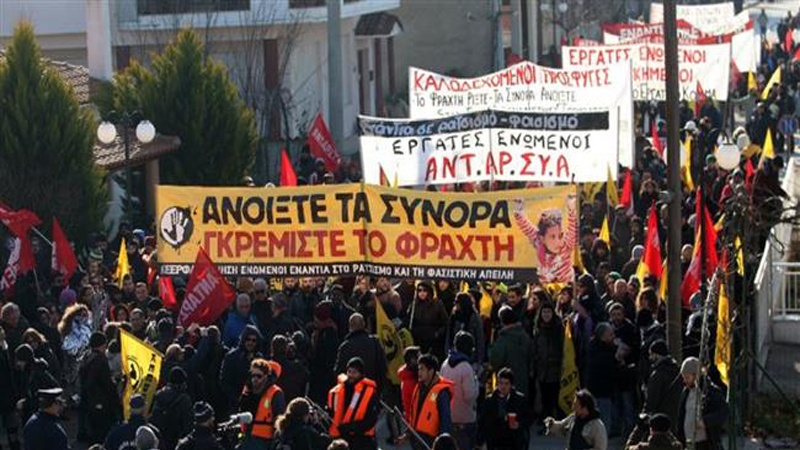 24 जनवरी 2016 की इस तस्वीर में यूनान के कस्टनीज़ क़स्बे में शरणार्थियों के समर्थन में आयोजित प्रदर्शन में भाग लेते आम लोग