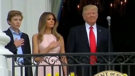 Melania nudges Trump to raise hand during national anthem