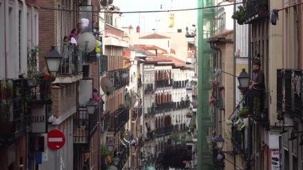Madrid neighbors greet each other with mops during COVID-19 lockdown