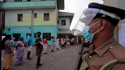 Sri Lankans, wearing masks, flock to voting centers for parliament election
