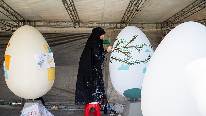 Seniman Iran sedang melukis Telur Nowruz.