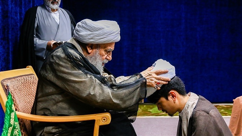 Ayatullah Karimi Jahromi memakaikan serban kepada santri asing di Qom, Selasa (30/5/2023).