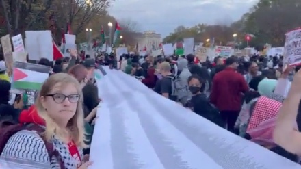 英でデモ参加者らが、殉教したパレスチナ人の子供の名前が掲載された横断幕を掲げる